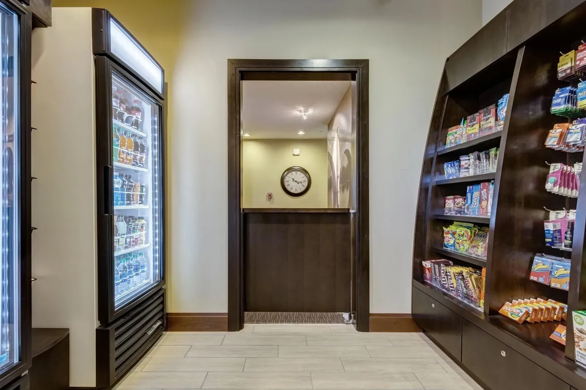 A convenient snack area featuring a vending machine, snack display, and a wall clock, creating an atmosphere of easy refreshment and casual snacking.